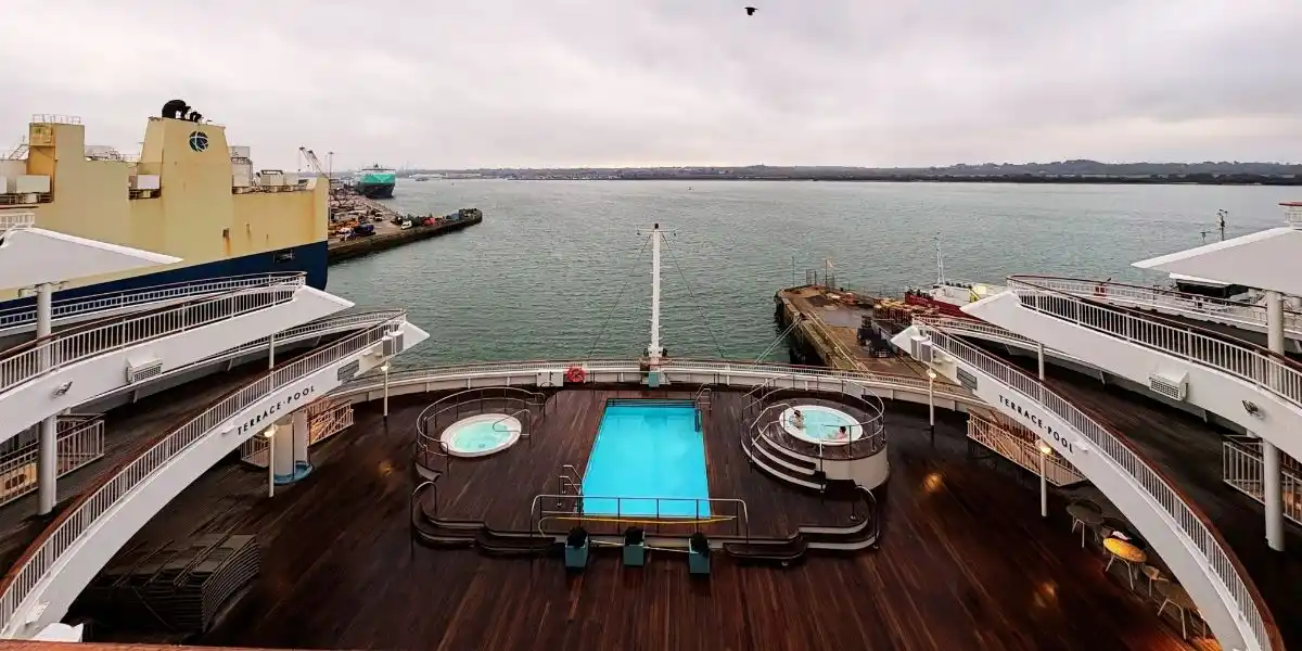 photo of the back of the ship on a grey day, looking out to sea, over the swimming pool and jacuzzi. first time cruise