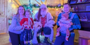 mum, dad, boy girl family sat with father christmas christmas in hampshire