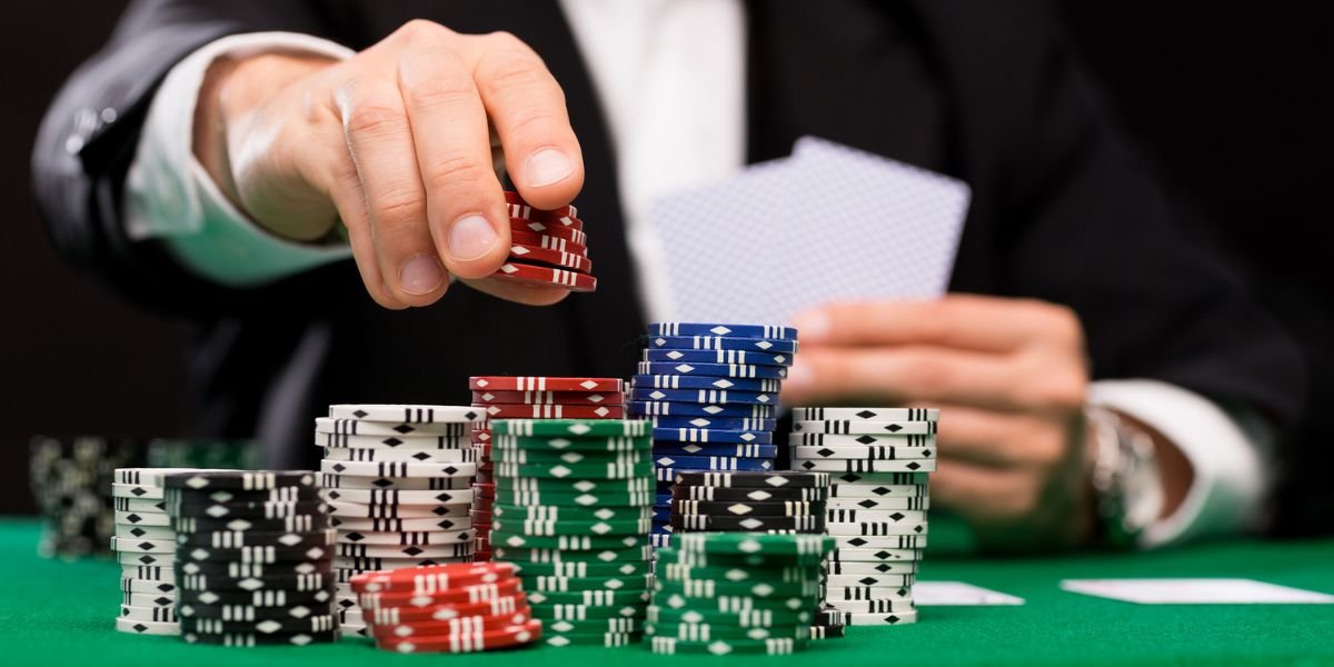 piles of brightly coloured casino chips with a man in the background adding red chips to the pile. lucky streaks