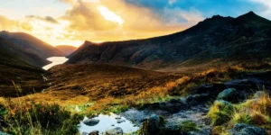 a sunset over a mountain viewed from the valley . Cue the main character moment