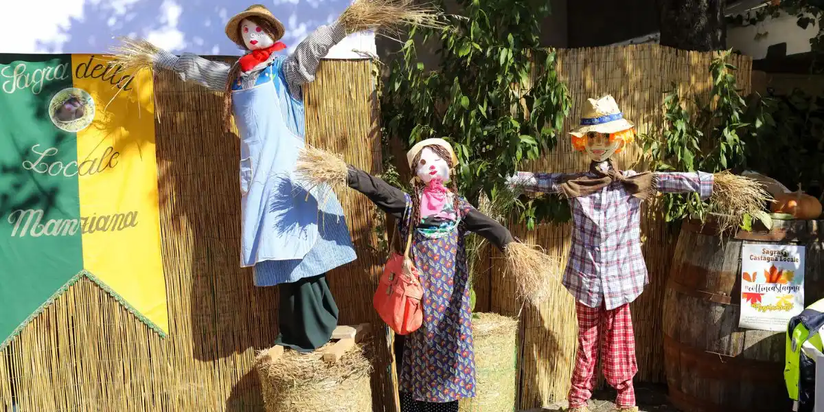 three scarecrows standing on hay bales