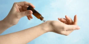 Travel habits that will boost your mental wellness, hands apply roll-oh essential oils