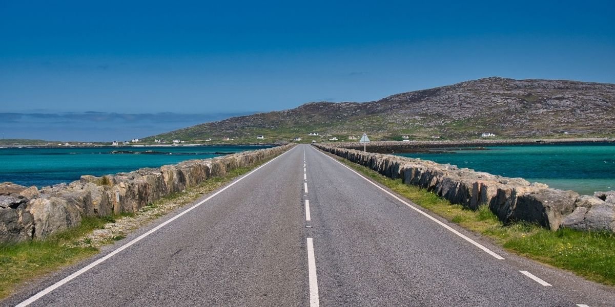 The causeway road link between the islands of Eriskay and South Uist in the Outer Hebrides, Scotland, UK. Taken on a clear, sunny day in summer with a blue cloudless sky
