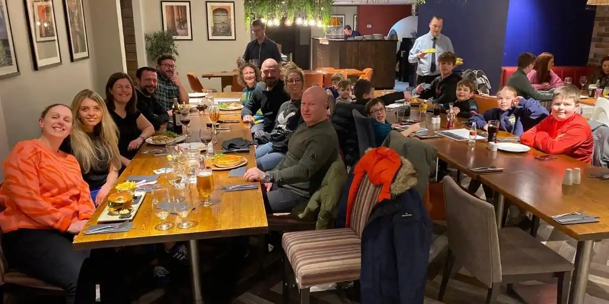 tips for family holidays, big group of adults and children sitting in a restaurant