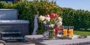 hot tub and bright colourful flowers on a table in a sunny outdoor setting
