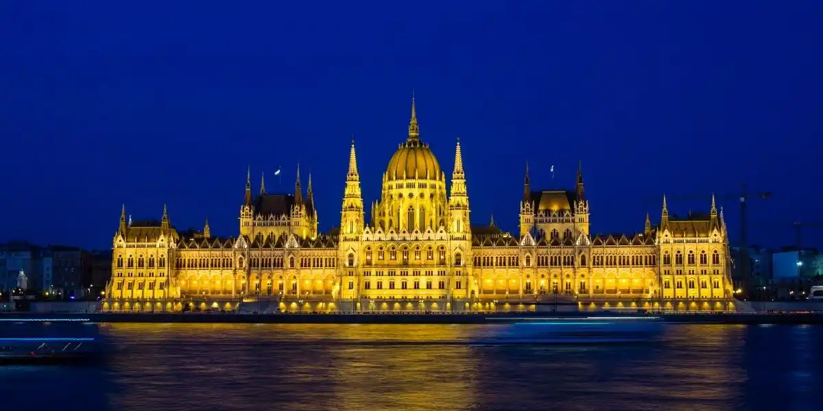 Illuminated Budapest parliament building at night with dark sky and reflection in Danube river, Hungary