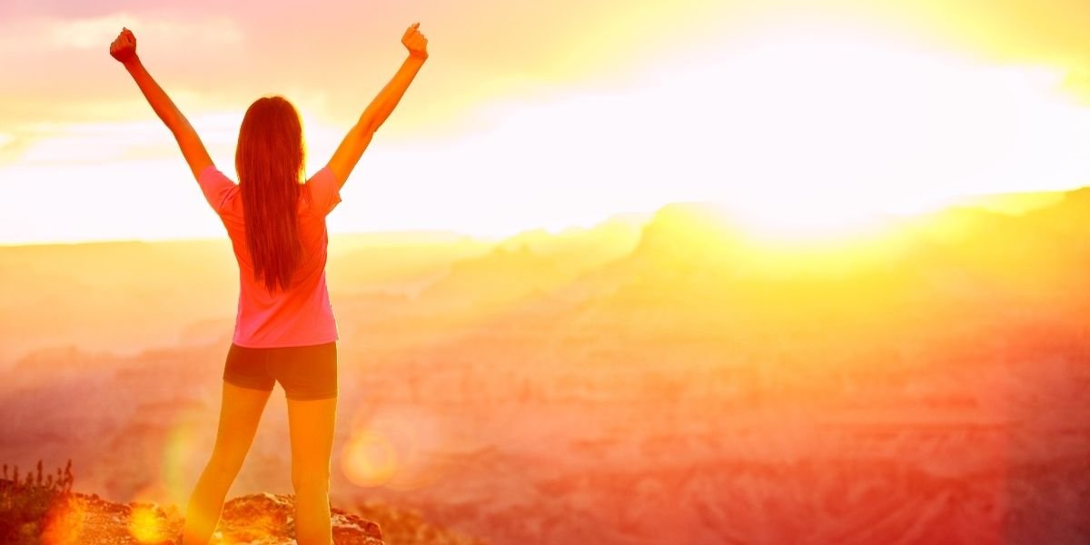 Freedom and adventure - woman happy, Grand Canyon. Free cheering with arms raised enjoying serene sunset in winning pose with arms stretched after hiking.