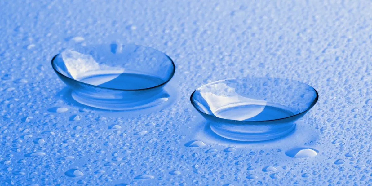 contact lenses on a glass surface with water droplets