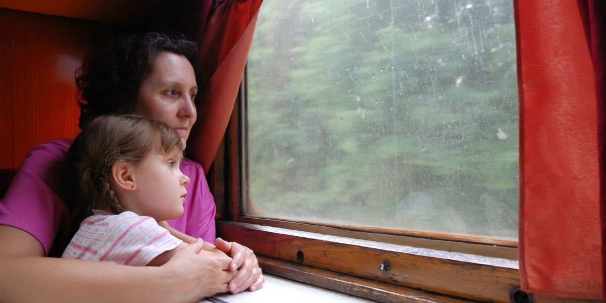 Generations long trip. Pensive woman with her granddaughter on a long train trip