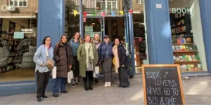 a group of people standing outside a bookshop