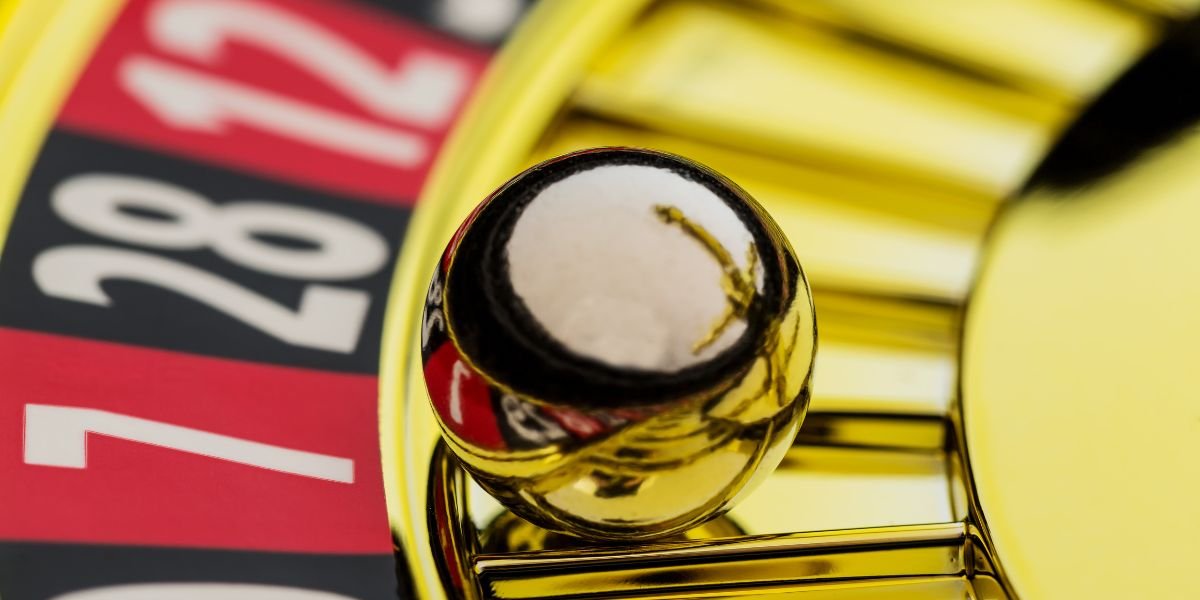 a gold roulette wheel where the ball has landed in red 7