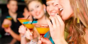 group of friends smiling and enjoying cocktails