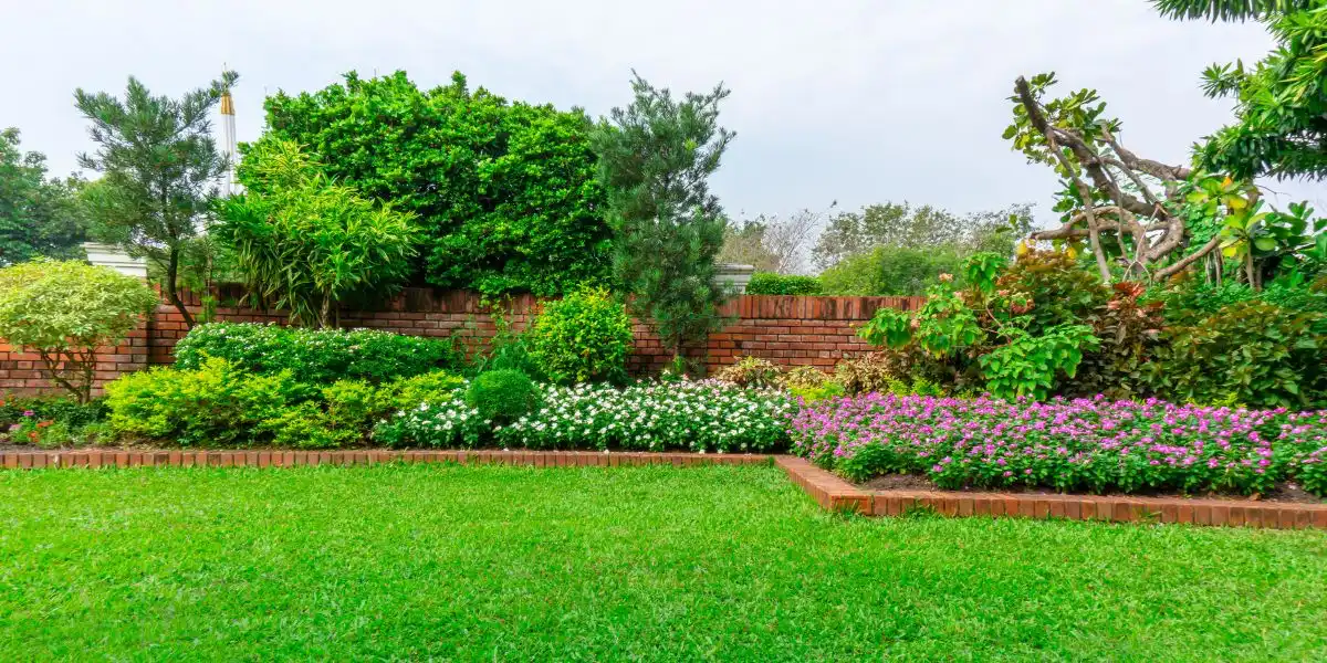 a walled garden with brick edging and lovely flowers
