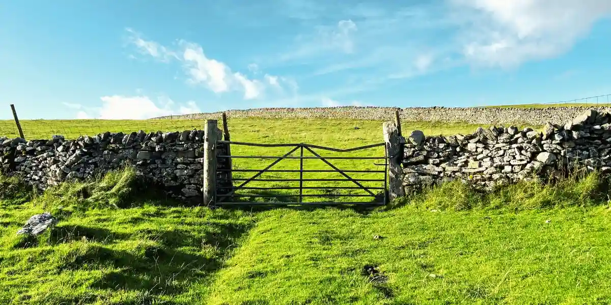Old farm gate, leading into the fields above, Kettlewell, Yorkshire, UK. Dry stone walls, with an old farm gate, leading into the fields high above