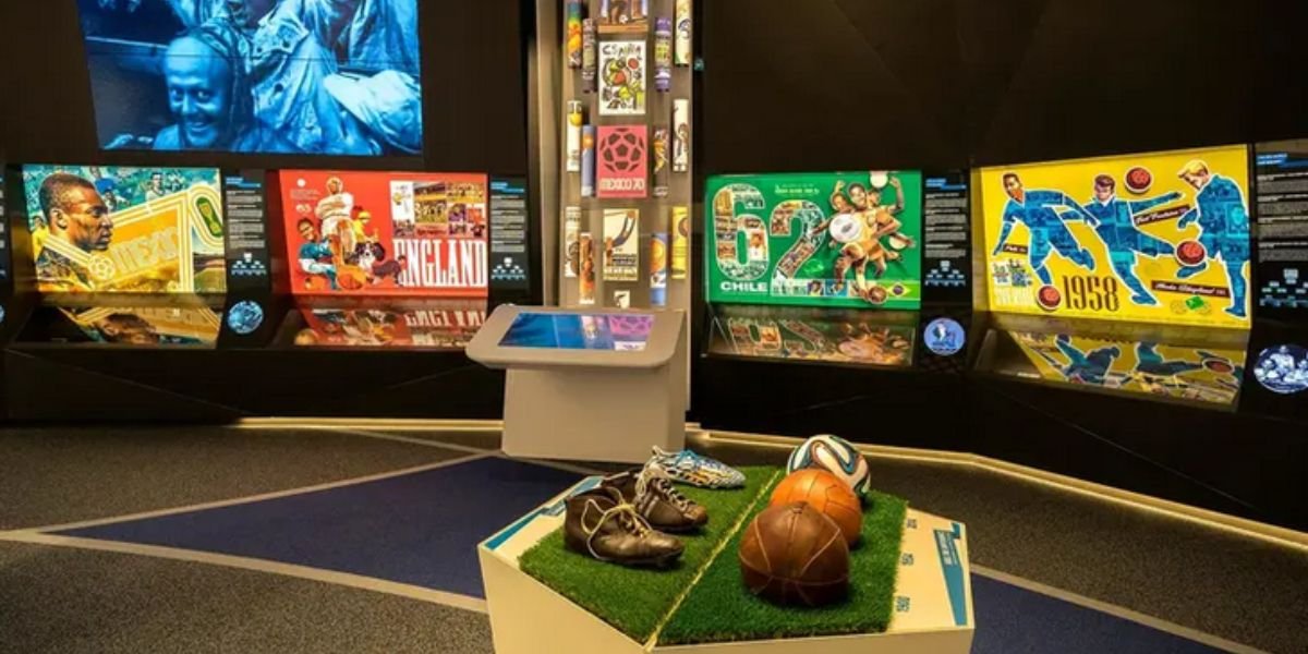 the inside of a football museum with a display of vintage shoes and balls