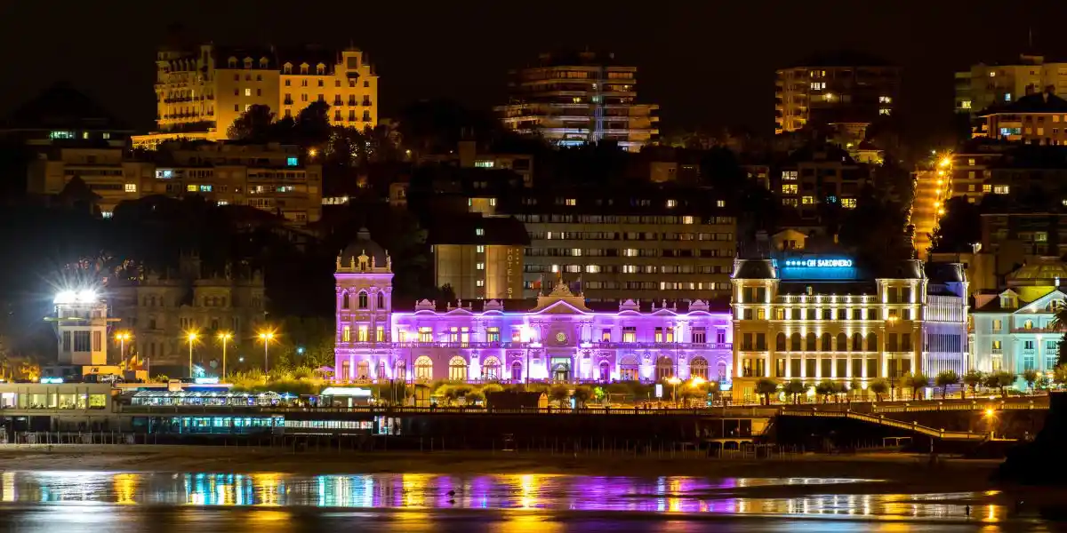 Panoramic view of Great Casino of Santander city iluminated at night and reflections in the water of the beach