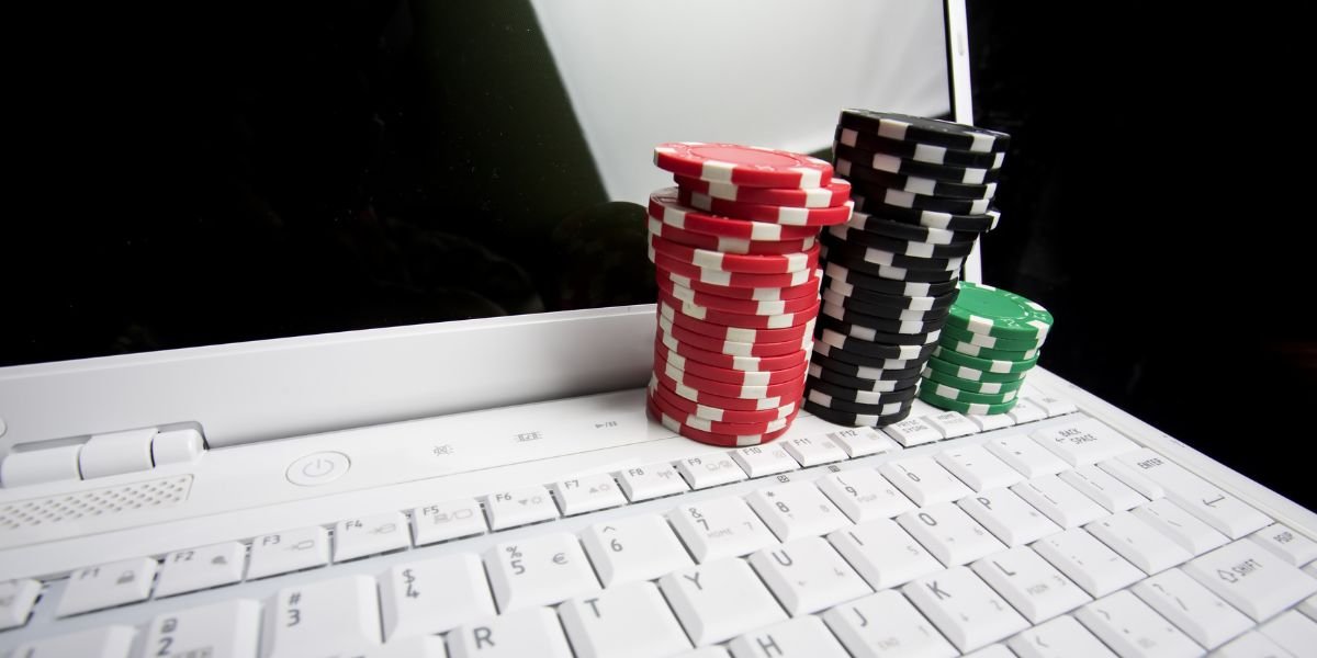 Concept - online poker. Gambling chips on white laptop computer. Online gaming Concept