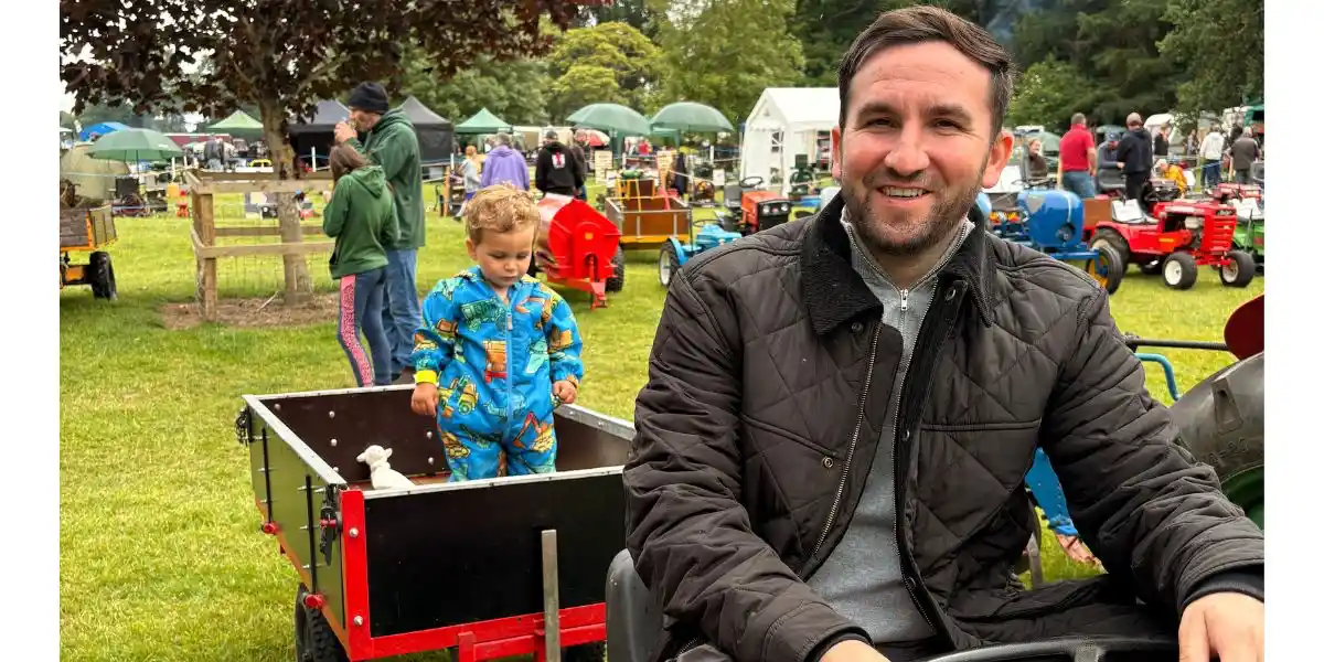man and son having fun on a toy tractor