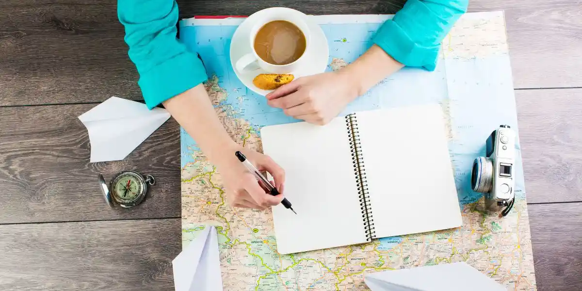 planner and cup of coffee while woman arranges travel plans