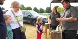 some people in a field at a caravan fair