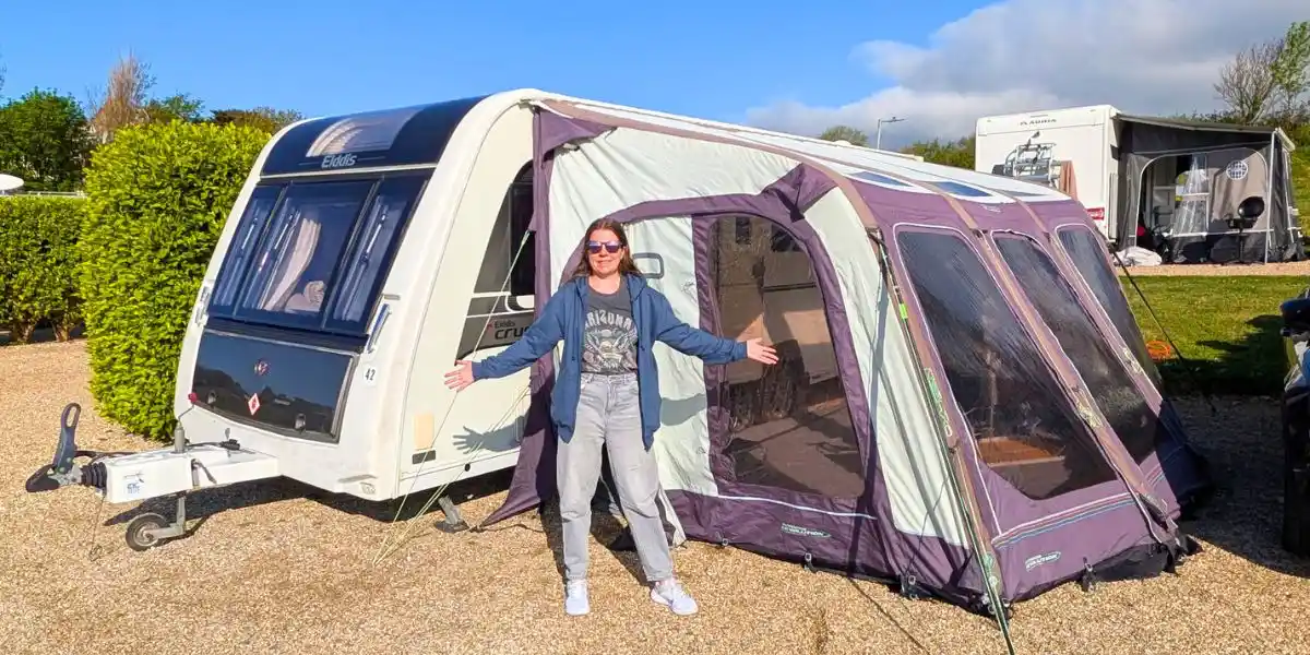 woman standing in front of a caravan and awning