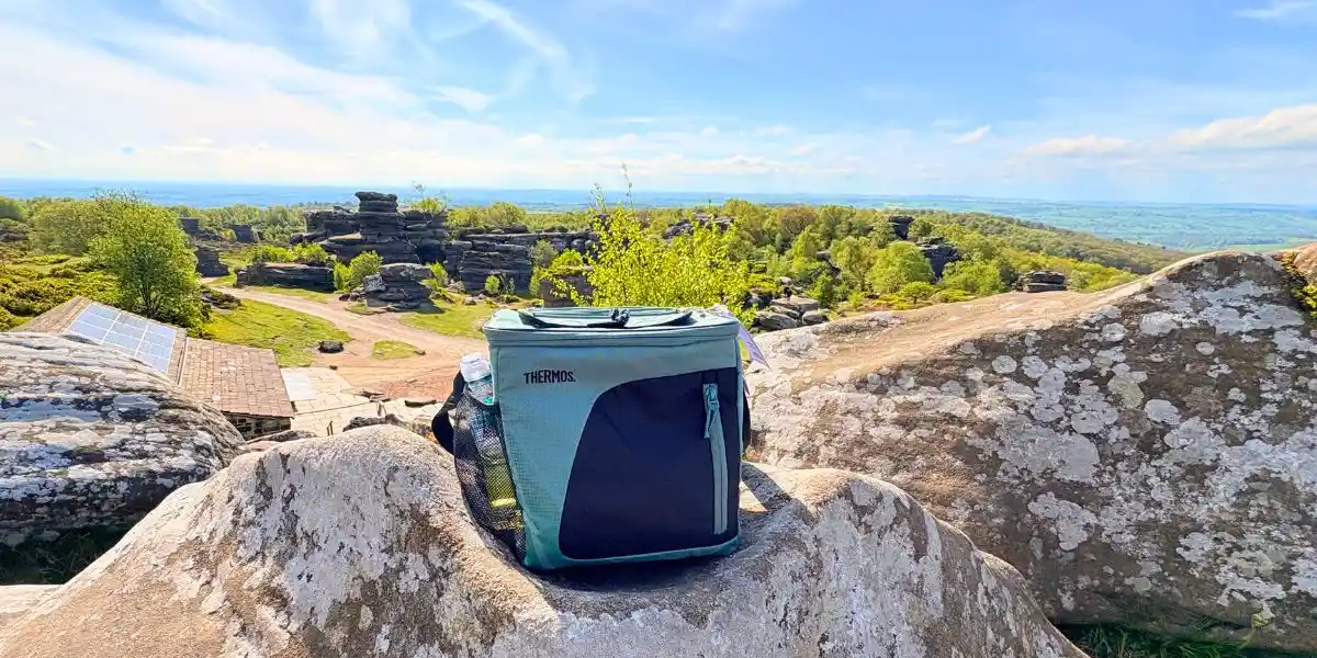 image of a thermos bag on some rocks overlooking countryside
