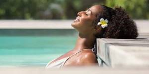 woman relaxing in a pool with a flower in her hair