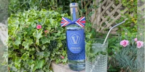bottle of v rum in a garden summer setting red white and blue ribbon