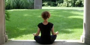 a woman meditates in her garden