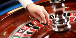 a roulette wheel with a hand about to spin. conceept of risk