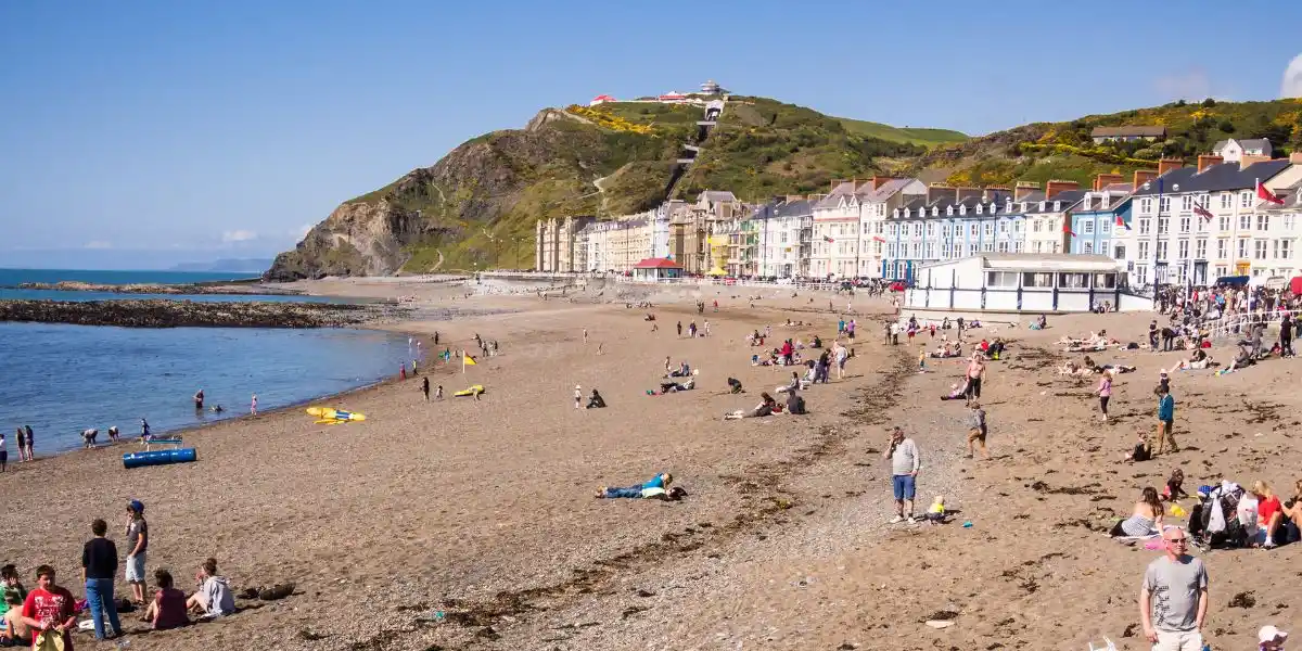 Seaside Beach Holiday in Wales, UK. People enjoying themselves on the beach at the seaside resort of Aberystwyth