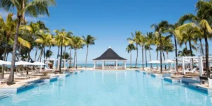 a swimming pool in a luxury beachside setting at the heritage resort in mauritius