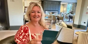 sarah holding a menu and a glass of wine