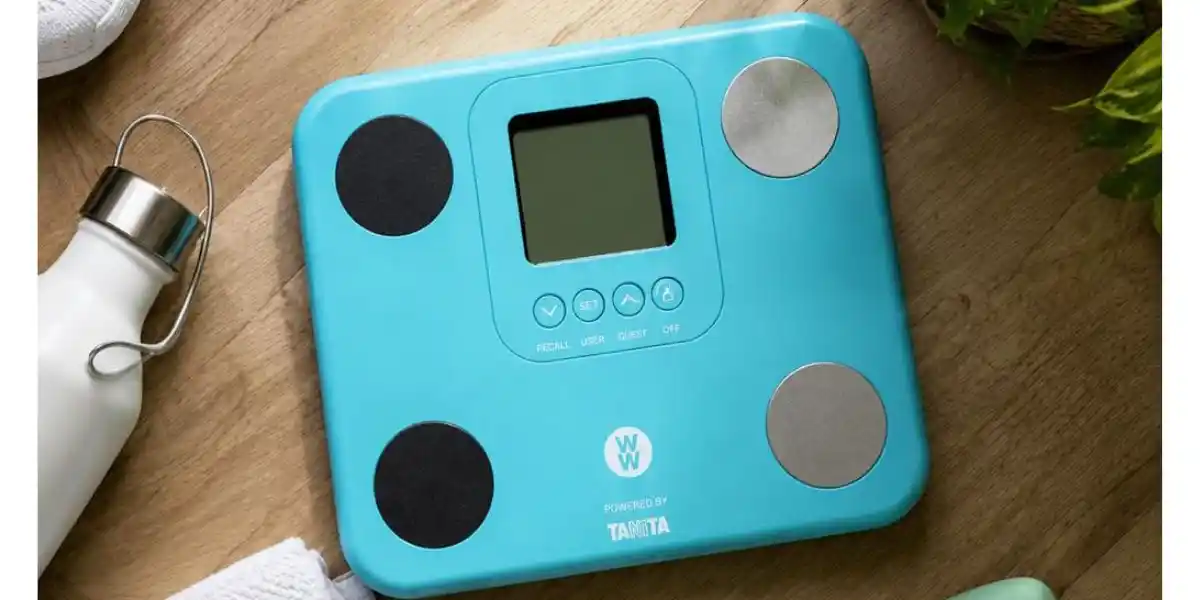 some blue tanita scales on a wooden floor