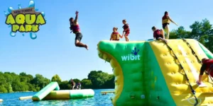 people jumping off an inflatable into water at the aqua park in the New Forest