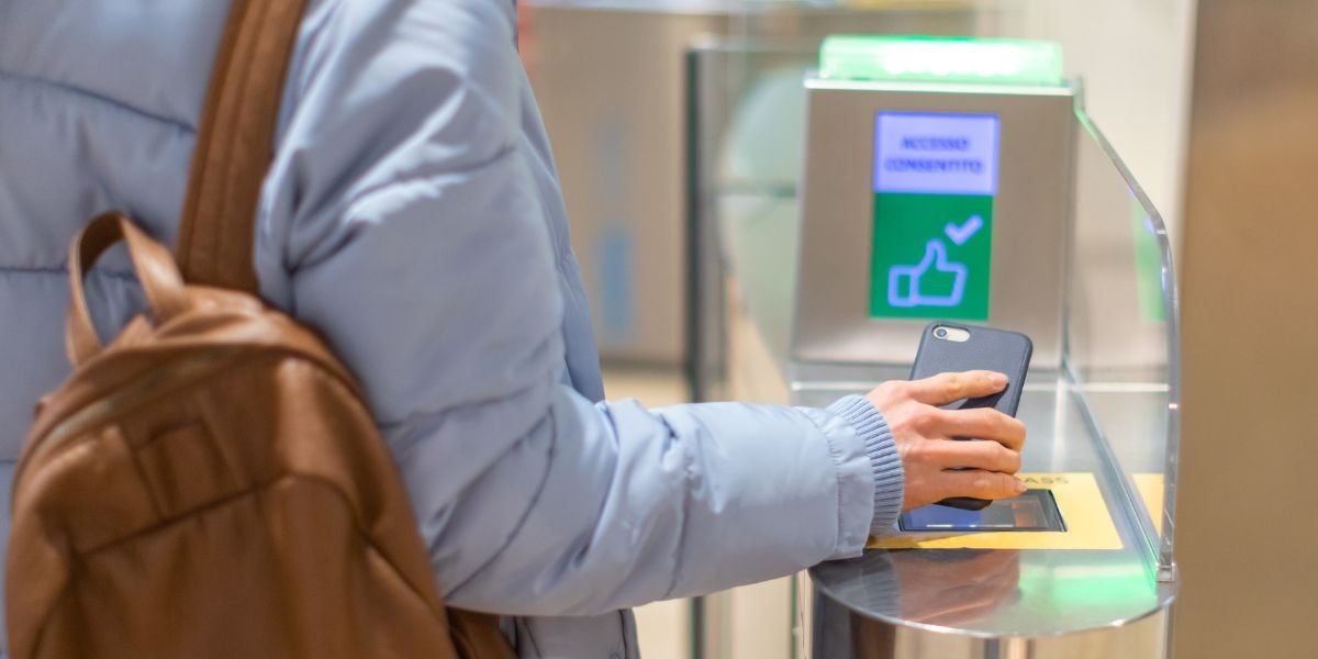 Electronic Boarding pass and passport control in the airport - hand with boarding pass on smartphone at the turnstile