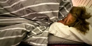 a boy asleep under a cute sleeping bag