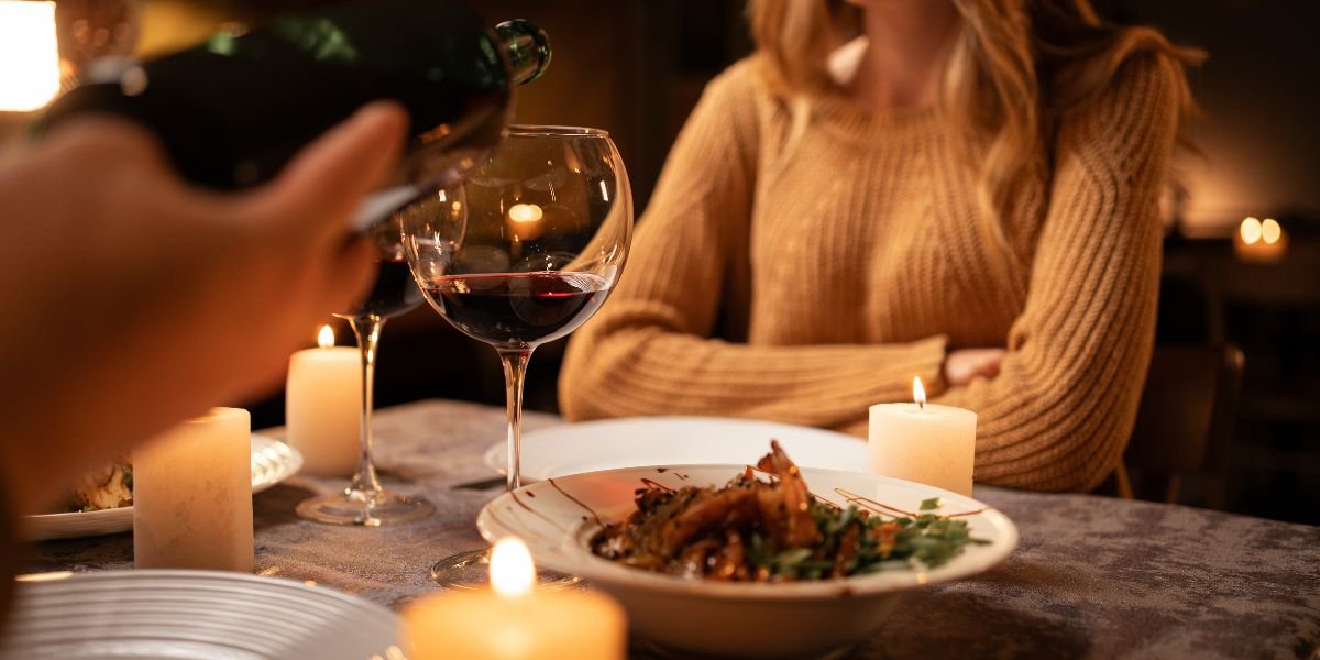 at home, having romantic dinner date with candles.