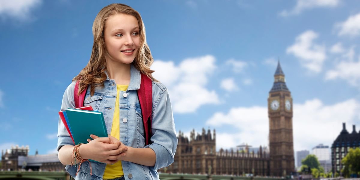 Education, school concept - happy smiling teenage student girl with bag and books in city of london learning english