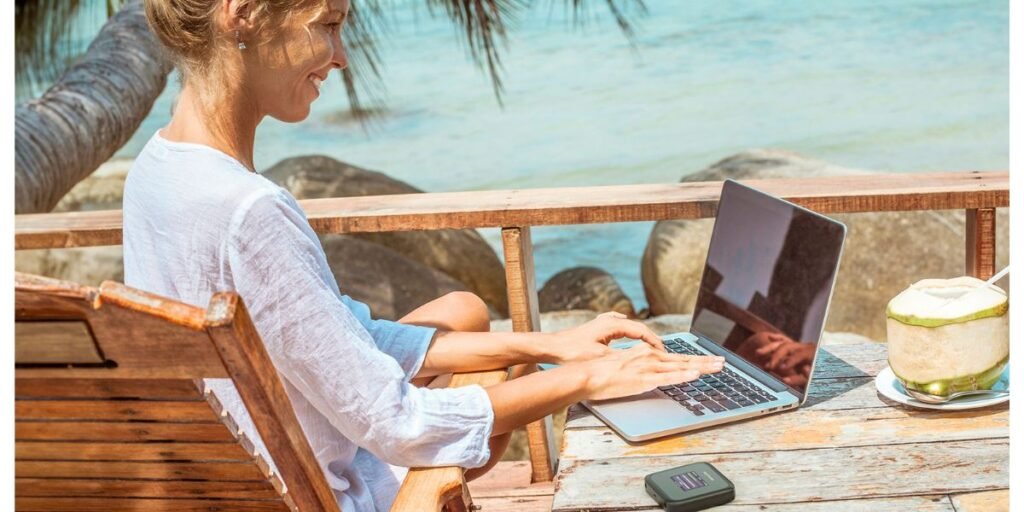 woman working on a laptop at the beach