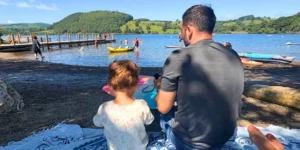 father and young son at the side of a lake at the park foot campsite