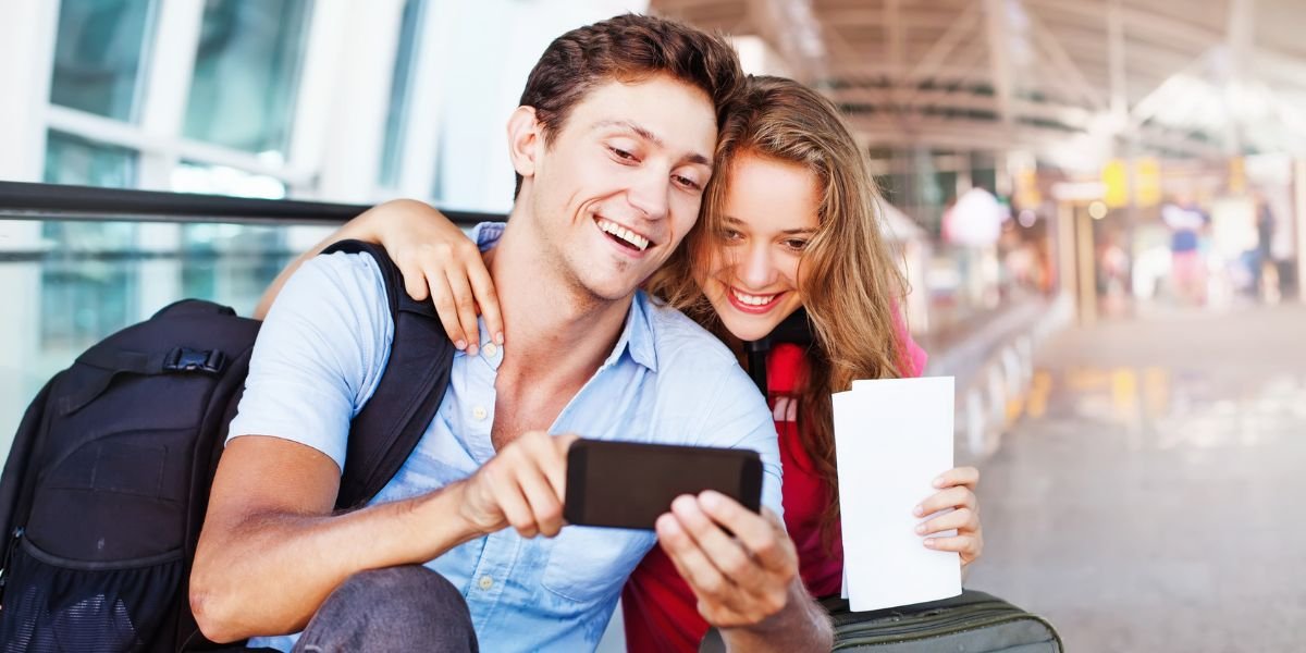 Two adults using a smart phone to stay entertained during a long travel journey