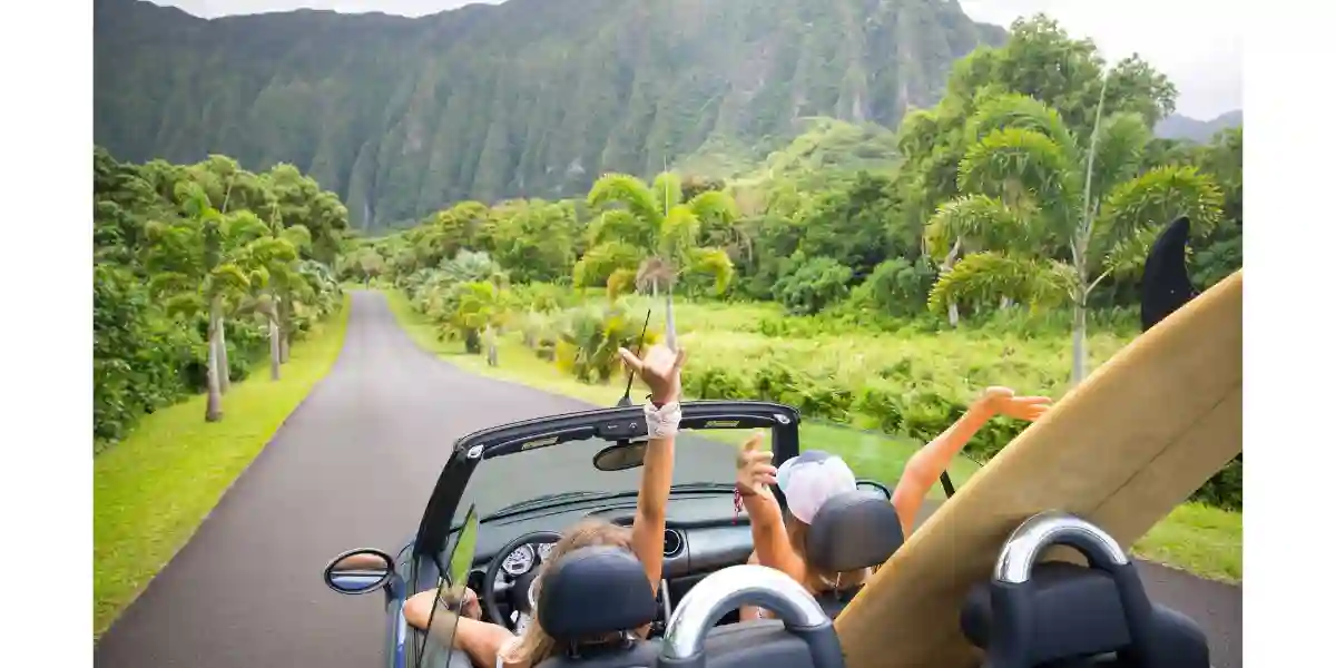people driving on Maui with a surfboard in the boot