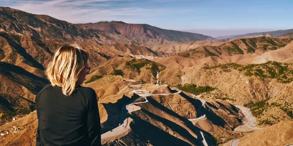 road trip through morocco, a womanlooks at the mountain pass in Tizi-n-Tichka