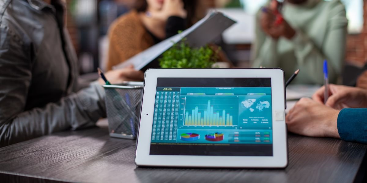 a tablet on the office table showing digital business graphs