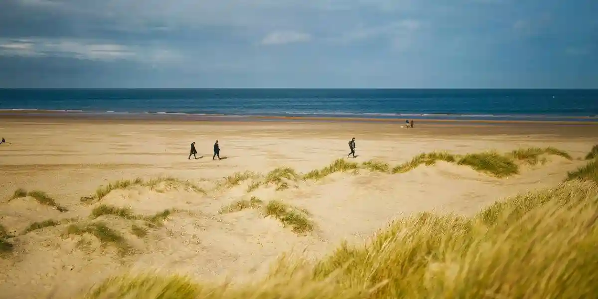 the norfolk coast with people walking along the beach