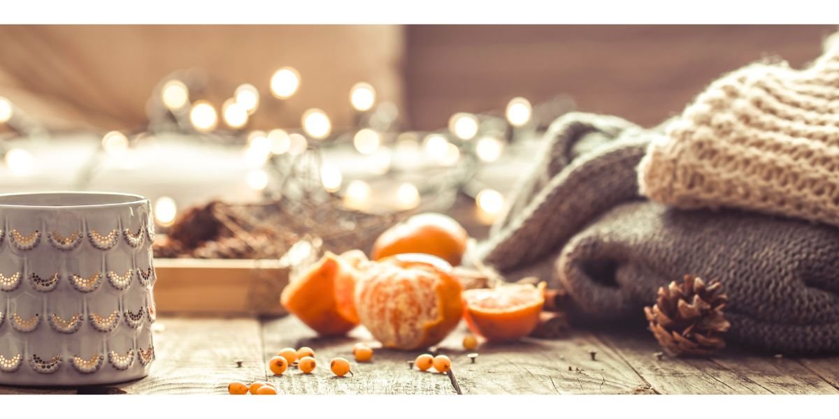 Beautiful Cup of tea with tangerines and sweaters on wooden background. Cosy autumn-winter concept