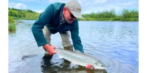 a man holding a dying salmon 