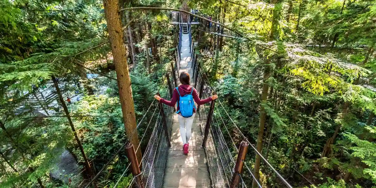 Canada travel tourist woman walking in famous attraction Capilano Suspension Bridge in North Vancouver