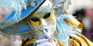 blue white & gold Venetian mask worn by a carnival goer 